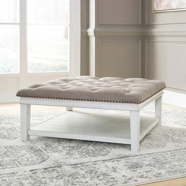 Farmhouse-style Kanwyn ottoman with button tufting and nailhead trim ��� Ashley UAE