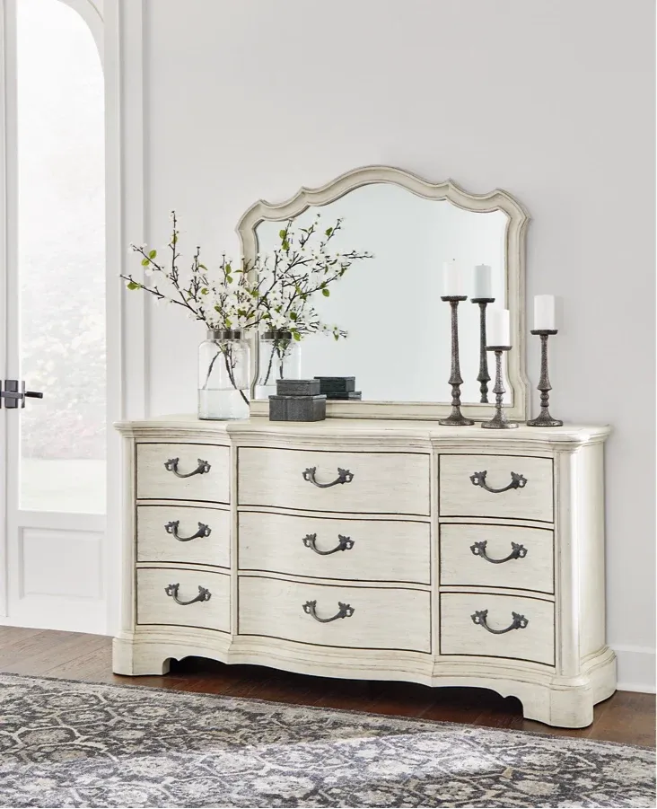 White dresser with mirror and decorative items in a room setting